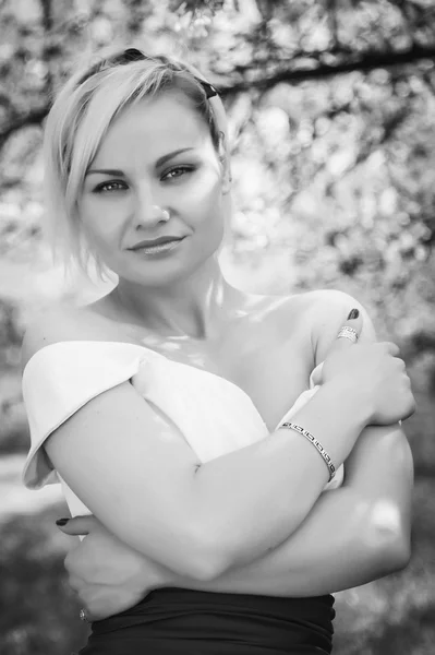 Blonde in white dress in spring garden — Stock Photo, Image