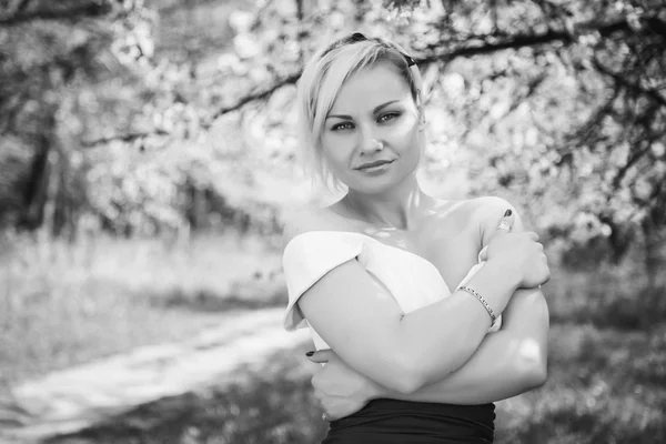 Blonde in white dress in spring garden — Stock Photo, Image