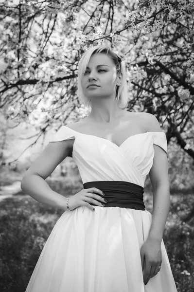 Blonde in white dress in spring garden — Stock Photo, Image
