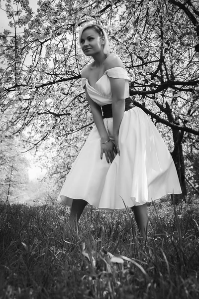 Rubia en vestido blanco en jardín de primavera —  Fotos de Stock