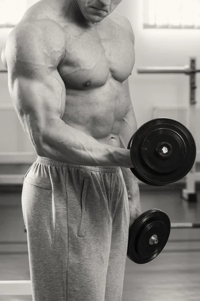 Homem musculoso trabalhando com halteres — Fotografia de Stock