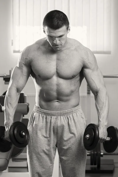 Hombre musculoso haciendo ejercicio con pesas —  Fotos de Stock