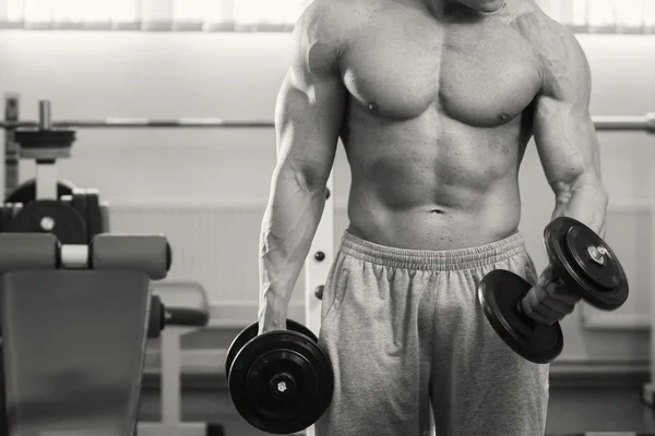 Muskulöser Mann, der mit Hanteln trainiert — Stockfoto