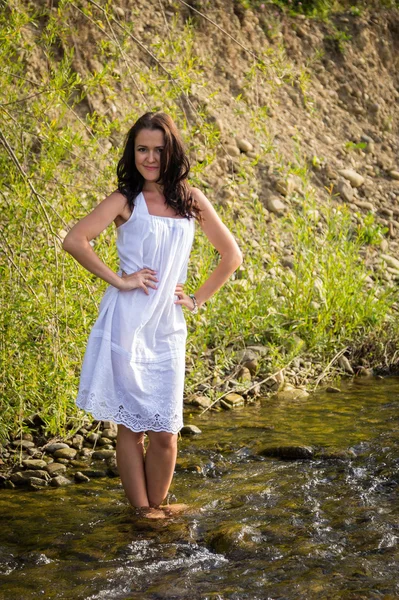 Woman standing barefoot in mountain river — Stock Photo, Image