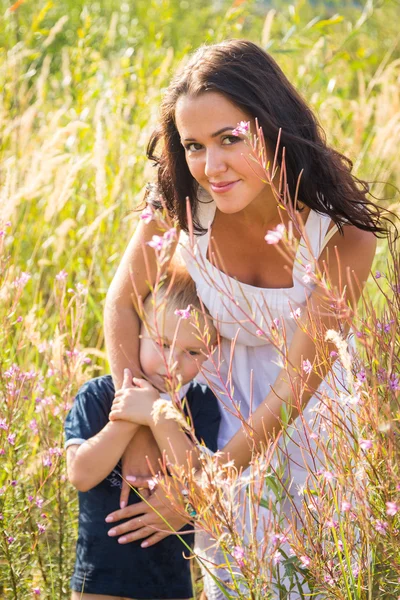 Mãe e filho em grama alta — Fotografia de Stock