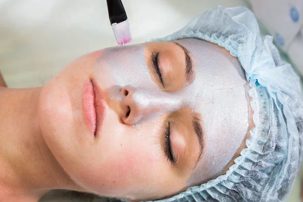 Therapist applying face mask to woman — Stock Photo, Image