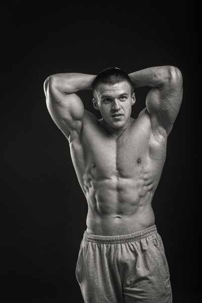 Muscular bodybuilder shows his muscles.