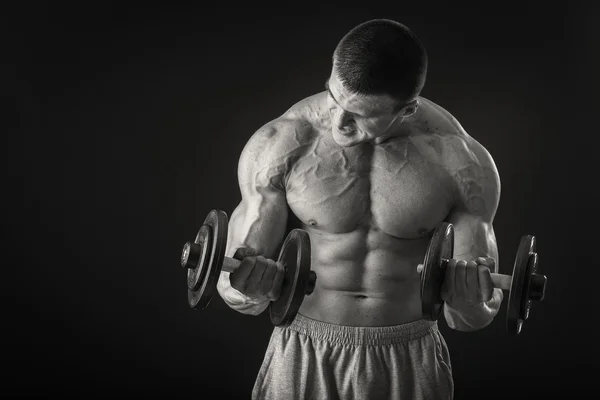 Man makes exercises with dumbbells — Stock Photo, Image