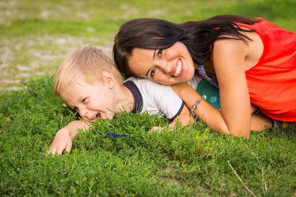 Mor og søn liggende på græsset - Stock-foto