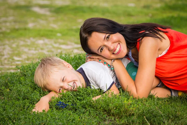 Mother and son lying on the grass — Stok fotoğraf