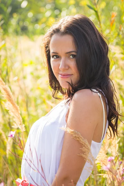 Fille en robe blanche debout dans l'herbe haute — Photo