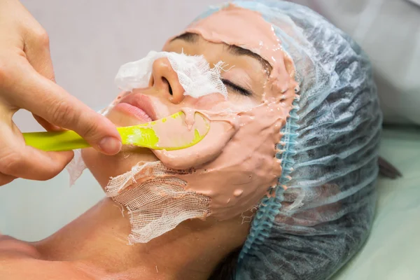 Mujer joven recibiendo máscara facial — Foto de Stock