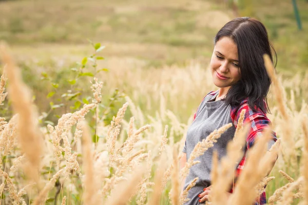 Jong meisje permanent in hoog gras — Stockfoto