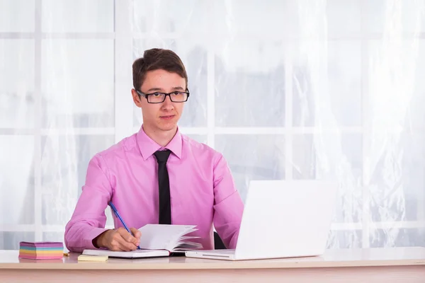 Estudiante trabajando en el ordenador portátil y toma notas —  Fotos de Stock