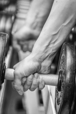 El spor salonunda bir dumbbell tutarak