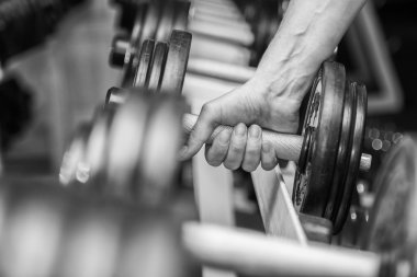 El spor salonunda bir dumbbell tutarak