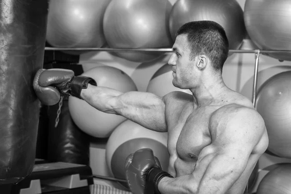 Gespierde man in bokshandschoenen in gym — Stockfoto