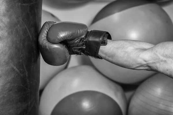 Homem de luvas de boxe bateu um saco de perfuração — Fotografia de Stock