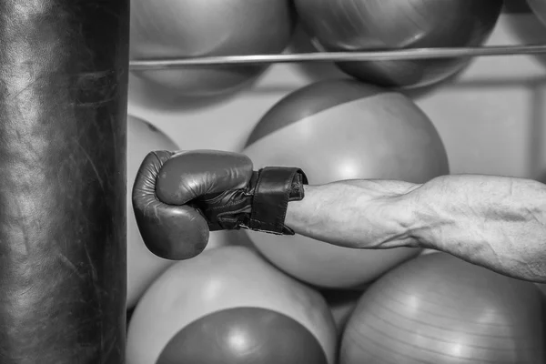 Hombre con guantes de boxeo golpeó un saco de boxeo — Foto de Stock