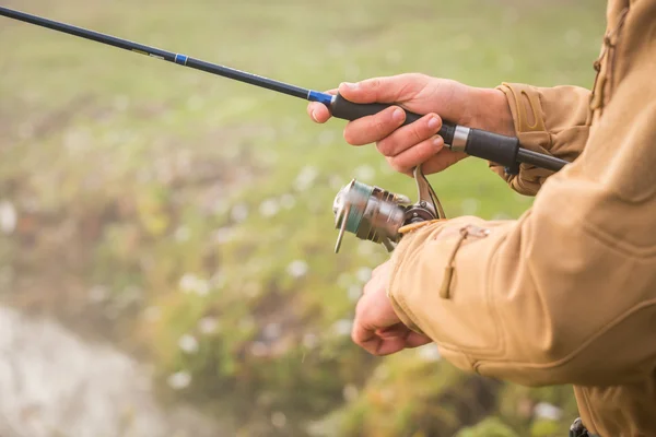 Pescatore con filatura sulla riva del fiume — Foto Stock