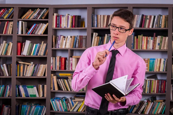 Student hält Buch in der Bibliothek — Stockfoto