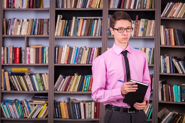 Estudiante sosteniendo libro en la biblioteca —  Fotos de Stock