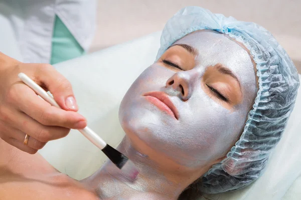 Therapist applying face mask to woman — Stock Photo, Image