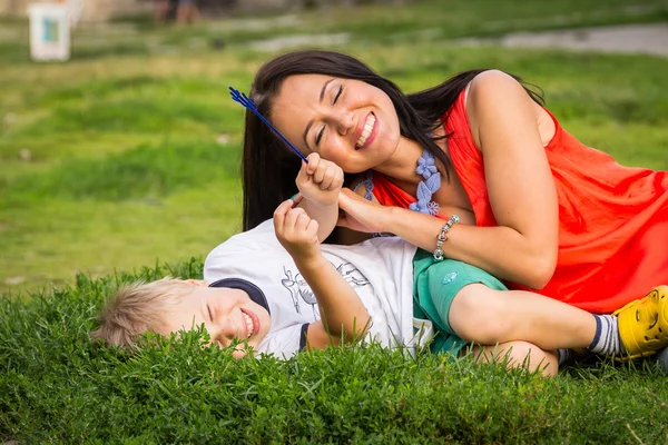 Mother and son lying on the grass — Stok fotoğraf
