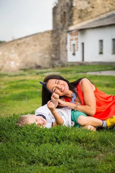 Mutter und Sohn liegen im Gras — Stockfoto