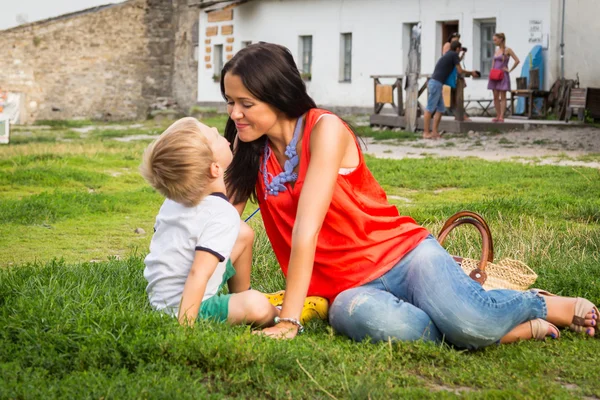 Mother and son lying on the grass — Stockfoto