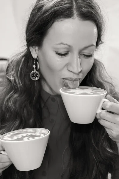 Meisje met kopje cappuccino in café. — Stockfoto