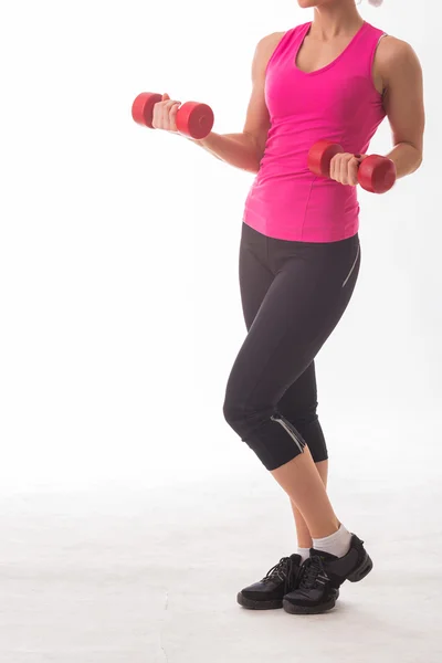 Woman in pink tank top holding dumbbells — Stock Photo, Image