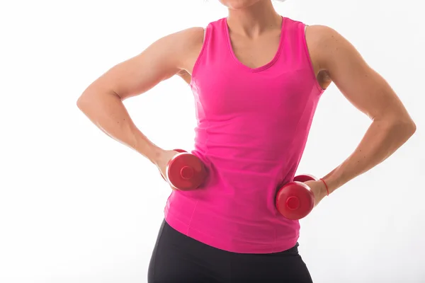 Woman in pink tank top holding dumbbells — Stock Photo, Image