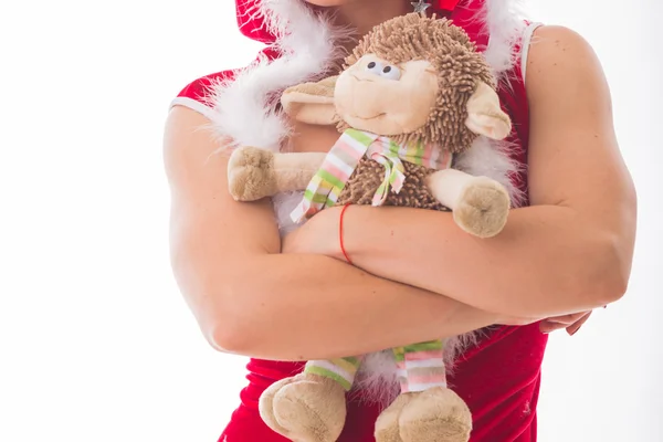 Блондинка в рождественском костюме с игрушечной бараниной — стоковое фото