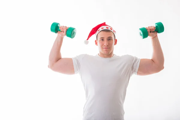 Man in a Christmas hat holding a dumbbells — Stock Photo, Image
