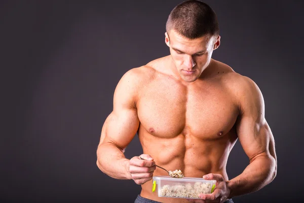 Homem muscular comer comida saudável — Fotografia de Stock