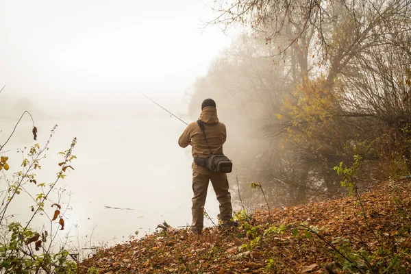 Pescatore con filatura sulla riva del fiume — Foto Stock