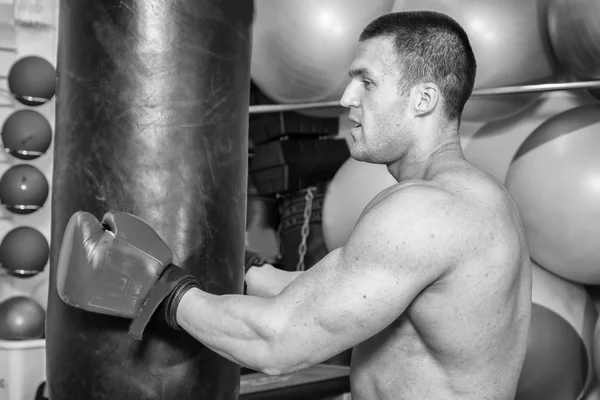 Uomo muscoloso in guanti da boxe in palestra — Foto Stock