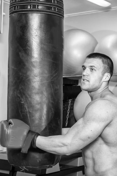 Hombre musculoso en guantes de boxeo en gimnasio — Foto de Stock