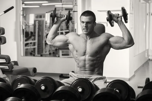 Muscular man working out with dumbbells — Stock Photo, Image
