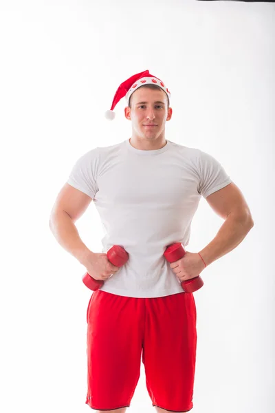 Man in a Christmas hat holding a dumbbells — Stock Photo, Image