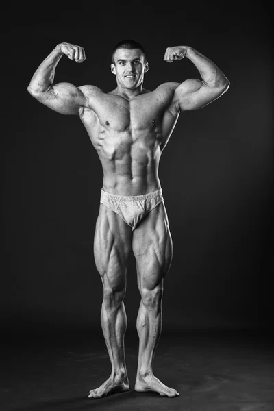 Muscular bodybuilder shows his muscles. — Stock Photo, Image
