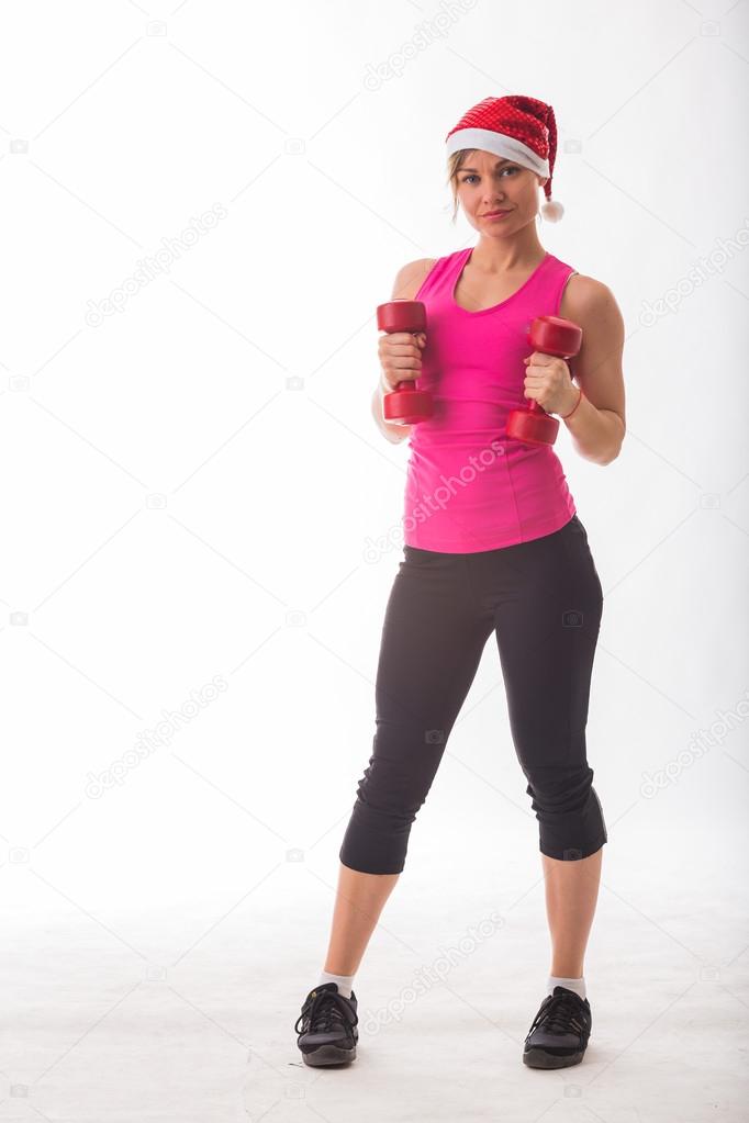 Blonde in a Christmas hat holding dumbbells