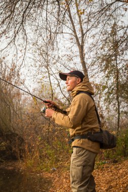 Nehir kıyısında dönen balıkçı