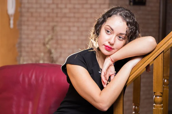 Beautiful romantic brunette on a red chair — Stock Photo, Image