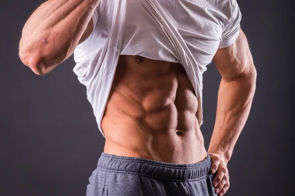 Man shows his abdominal muscles — Stock Photo, Image