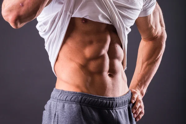 Man shows his abdominal muscles — Stock Photo, Image