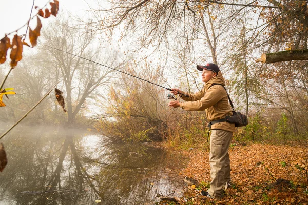 Visser met spinnen op de oever van de rivier — Stockfoto