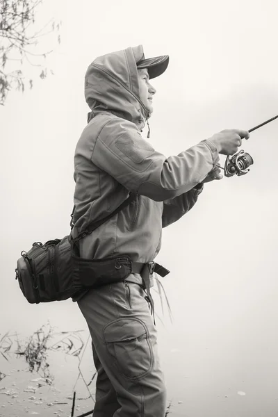 Pescador con spinning en la orilla del río. — Foto de Stock