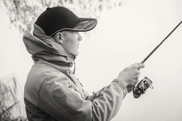 Pescador con spinning en la orilla del río. — Foto de Stock